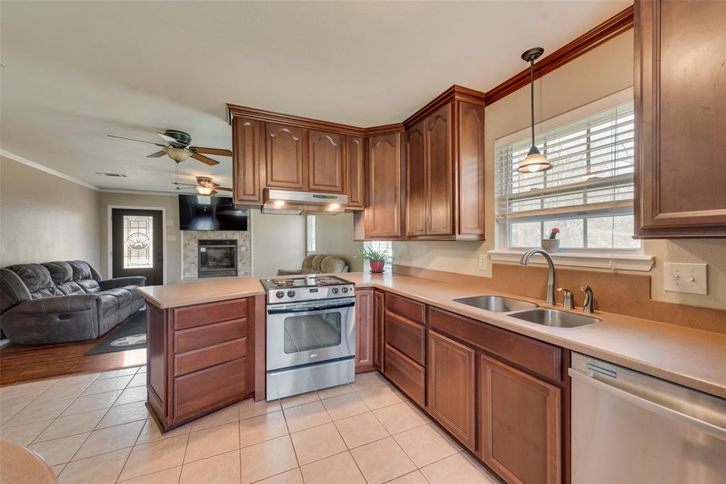 a kitchen with stainless steel appliances granite countertop a sink window and cabinets