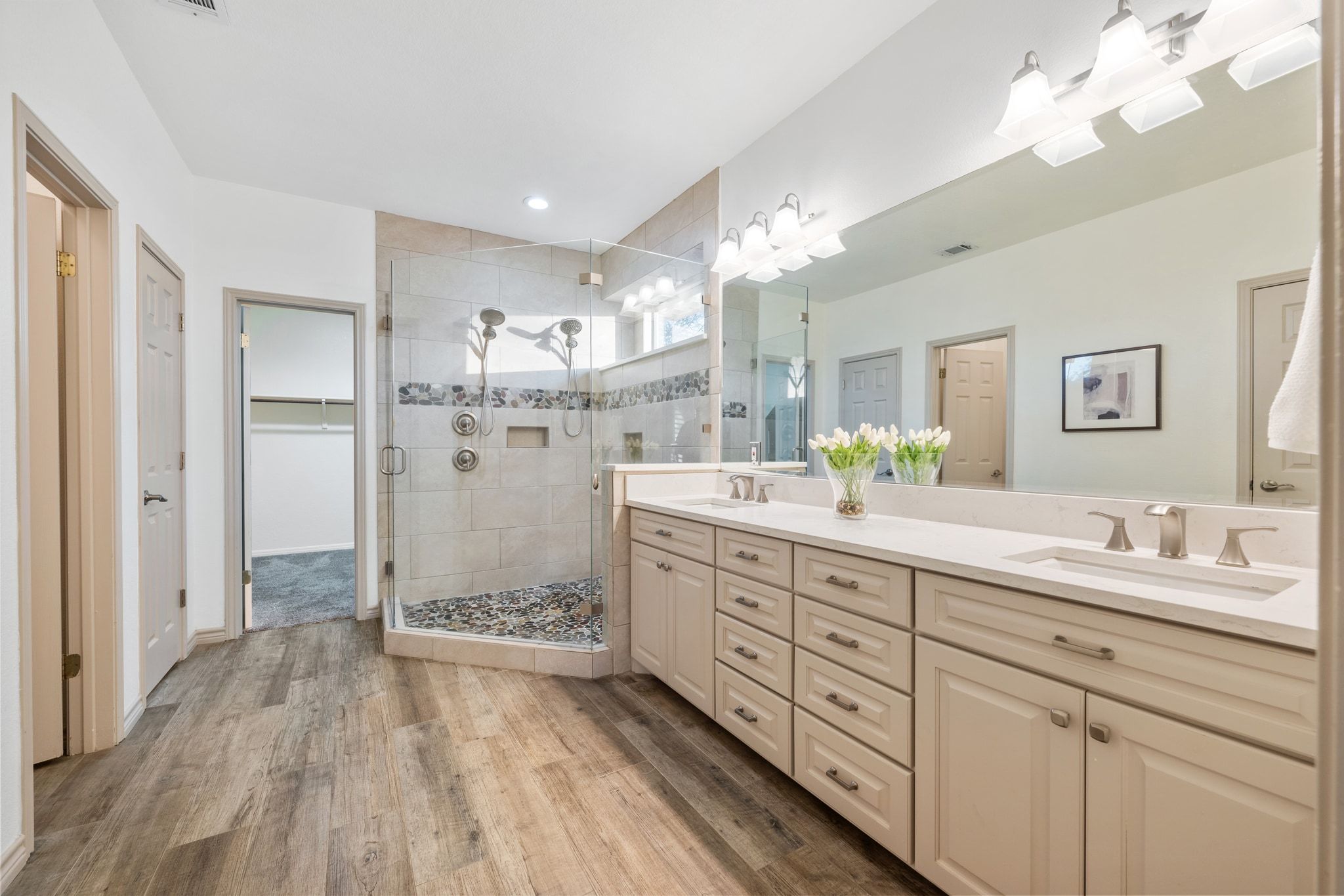 5100 Hadle Cove Austin, TX 78730 - Photo 13 of 31 First floor primary bathroom has been remodeled and feels like a spa with a beautiful shower with two shower heads, a long vanity with two sinks. Large walking closet.