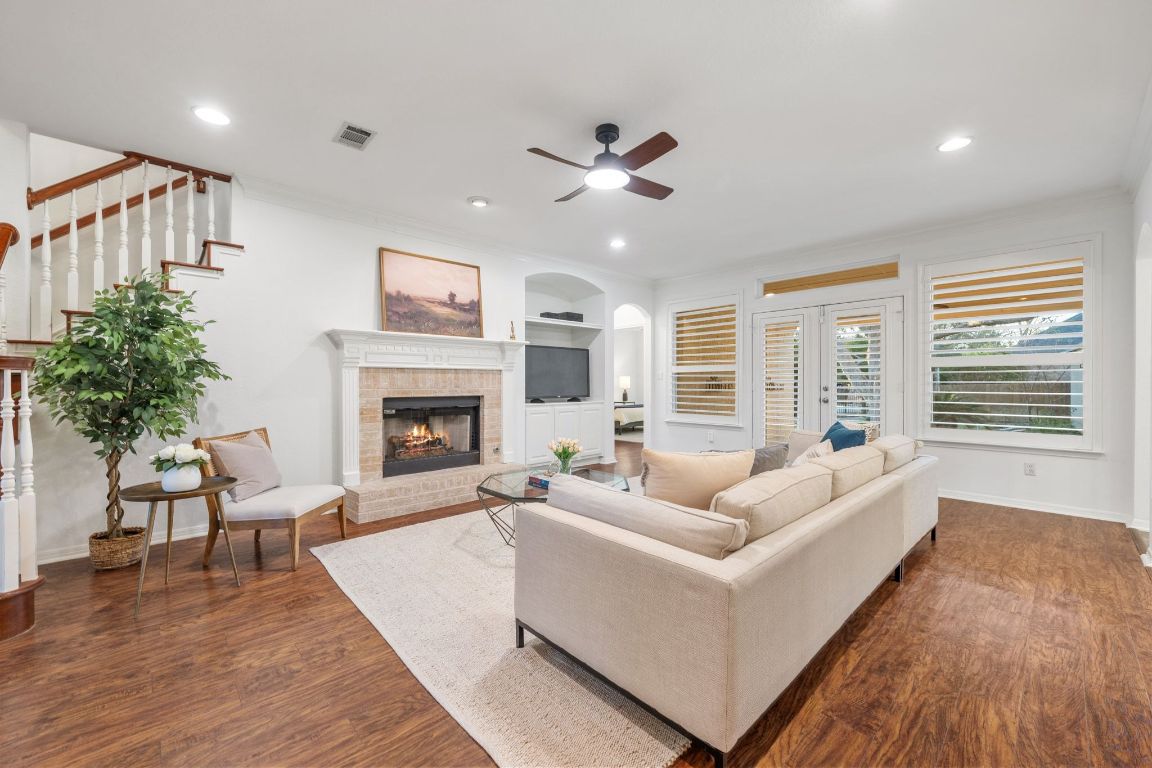 5100 Hadle Cove Austin, TX 78730 - Photo 2 of 32 Inside the home has been freshly painted and offers wood floors on the main level for an elevated feel. The living room opens to the kitchen and back patio, which makes for great for entertaining. The gas fireplace is perfect for staying warm on cold days.