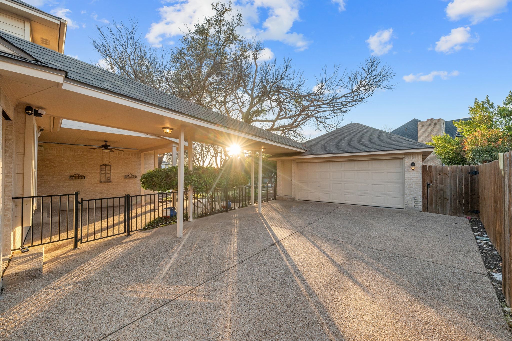 5100 Hadle Cove Austin, TX 78730 - Photo 25 of 31 The home offers a long flat driveway, 2 car garage. Also, pictured is the outdoor, covered patio (and the sunset).