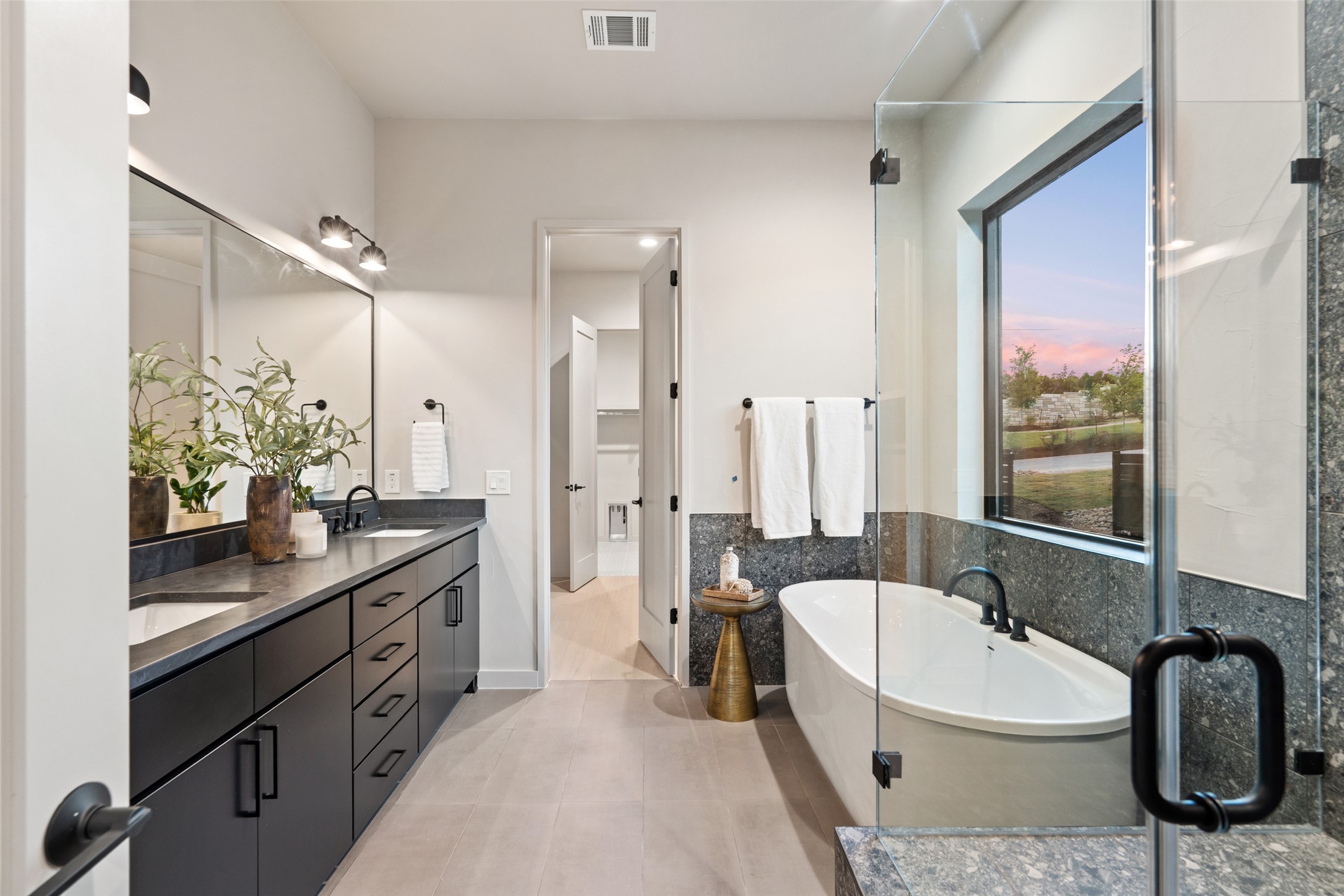 9803 Ribelin Ranch Court, Unit 6 Austin, TX 78750 - Photo 11 of 31 A well-appointed bath features a dual vanity, a soaking tub, and a spacious glass-enclosed shower.