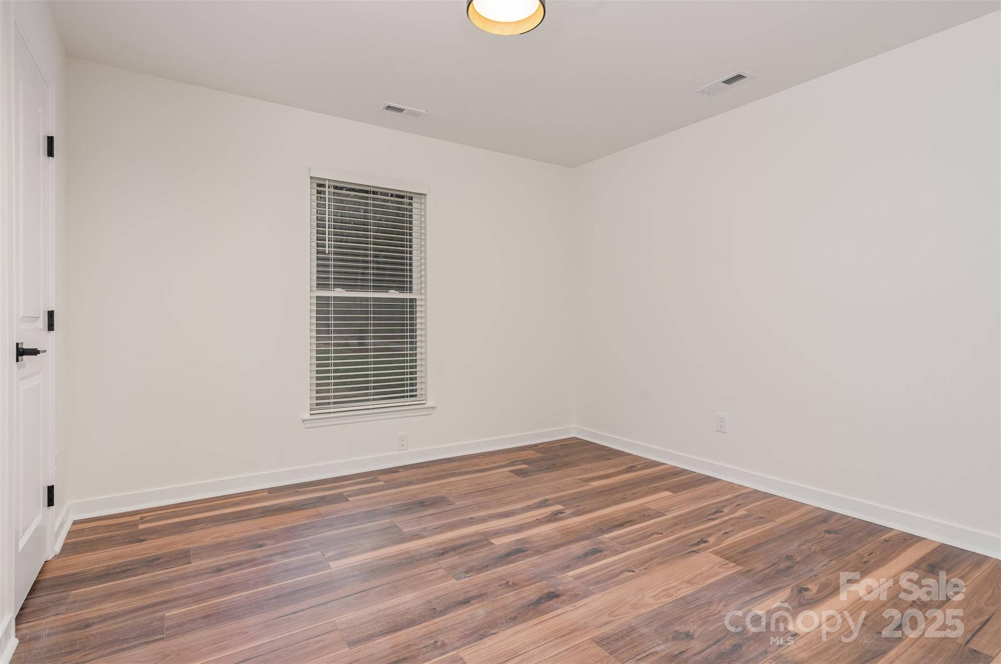 4169 Stack Road Harrisburg, NC 28075 - Photo 18 of 29 a view of an empty room with wooden floor and a window