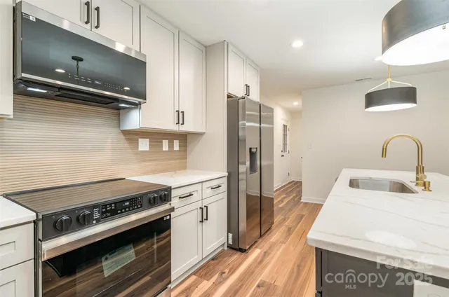 a kitchen with stainless steel appliances a stove a sink and a refrigerator