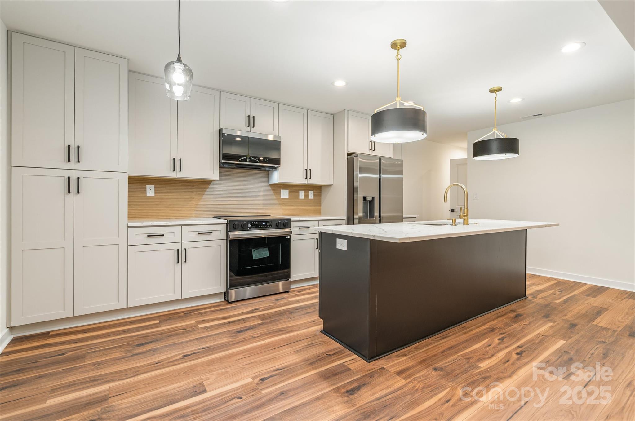 4169 Stack Road Harrisburg, NC 28075 - Photo 8 of 29 a kitchen with kitchen island sink stove and cabinets