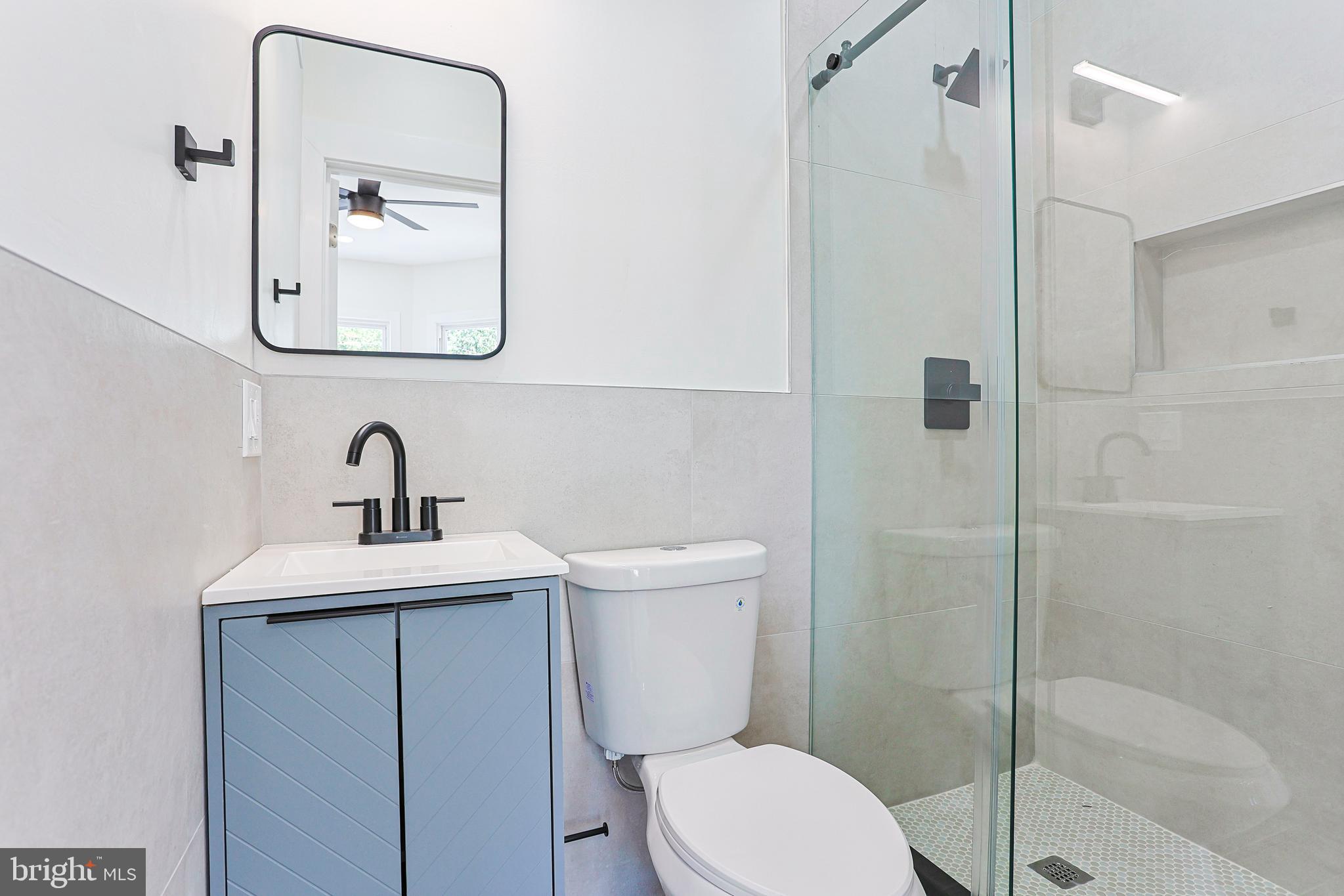 5520 Pemberton Street Philadelphia, PA 19143 - Photo 22 of 28 a bathroom with a toilet a sink and mirror