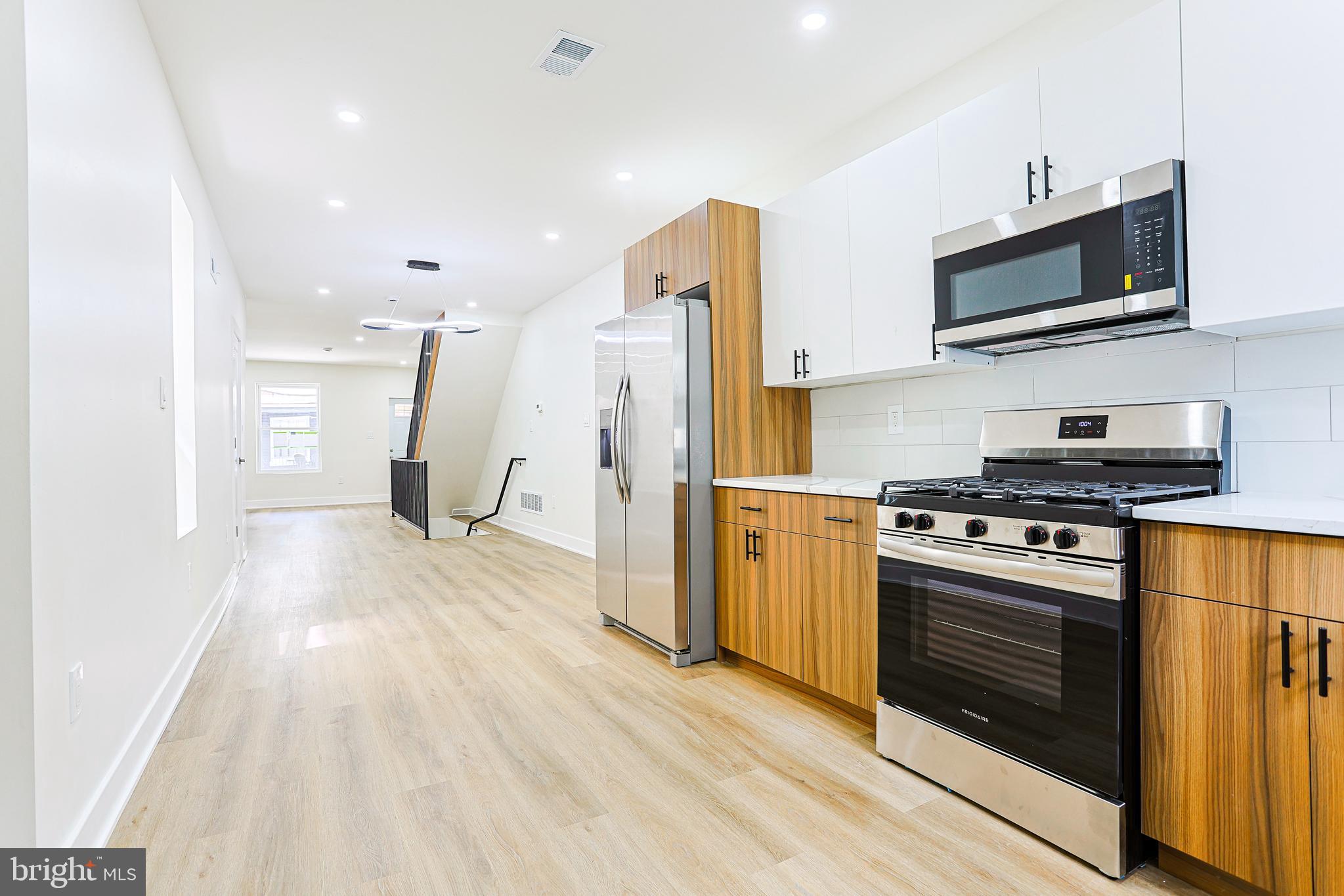 5520 Pemberton Street Philadelphia, PA 19143 - Photo 5 of 28 a kitchen with stainless steel appliances kitchen island granite countertop a stove a refrigerator and a microwave