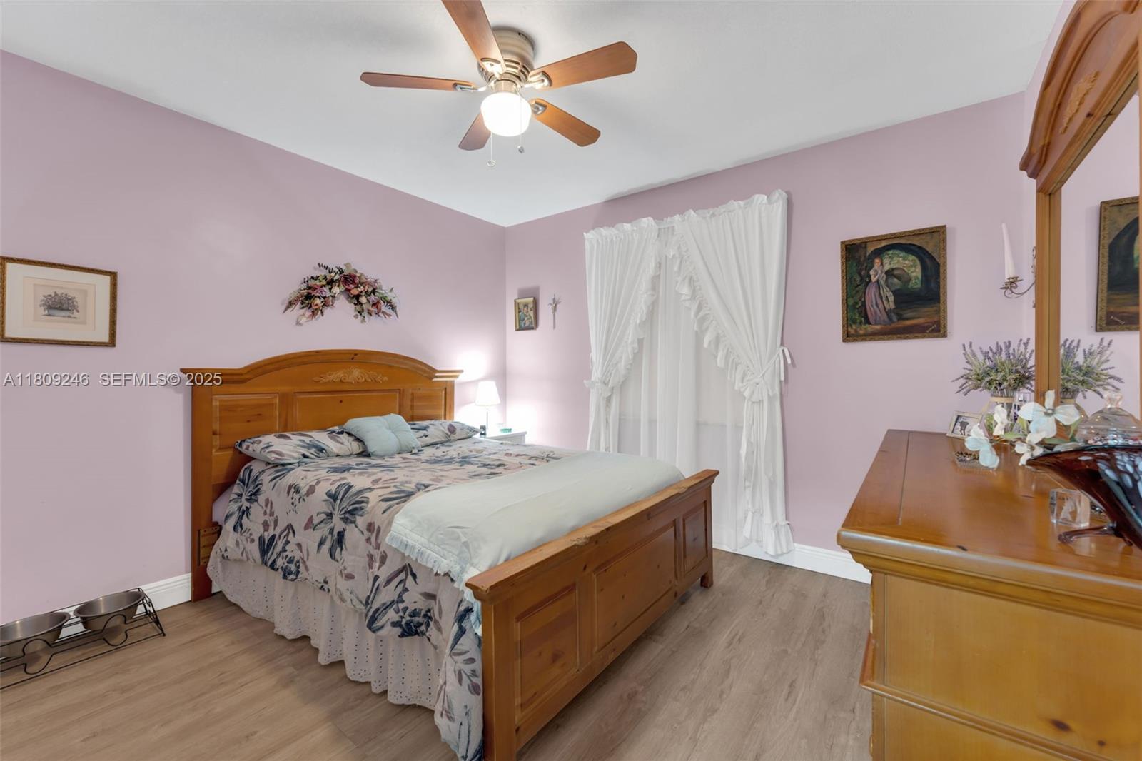 10813 Southwest 158th Lane Miami, FL 33157 - Photo 17 of 27 a bedroom with a bed and a chandelier