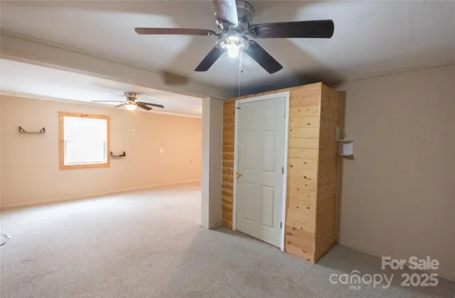 en empty room with windows and ceiling fan