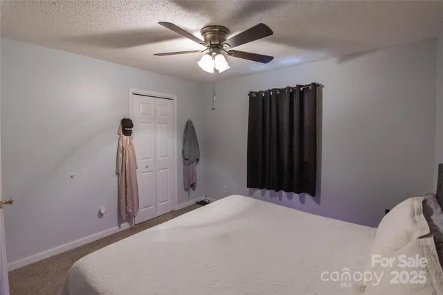 a bed room with a bed and a ceiling fan