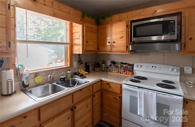 a kitchen with sink a microwave a stove and cabinets