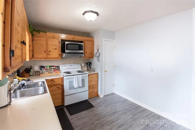 a kitchen with stainless steel appliances a stove a sink and a microwave