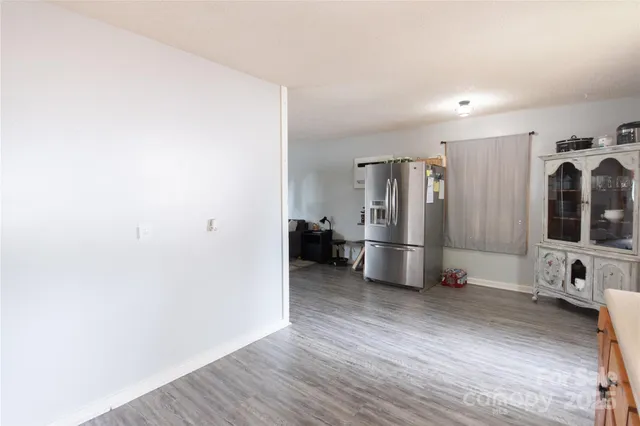 a view of a kitchen with refrigerator and wooden floor