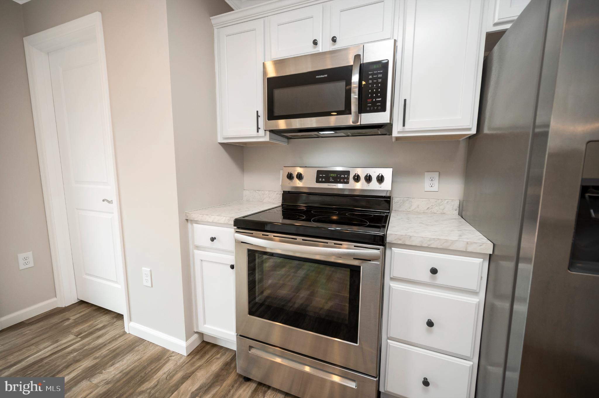 6112 Eds Road Mineral, VA 23117 - Photo 12 of 39 a kitchen with stainless steel appliances granite countertop white cabinets a stove top oven
