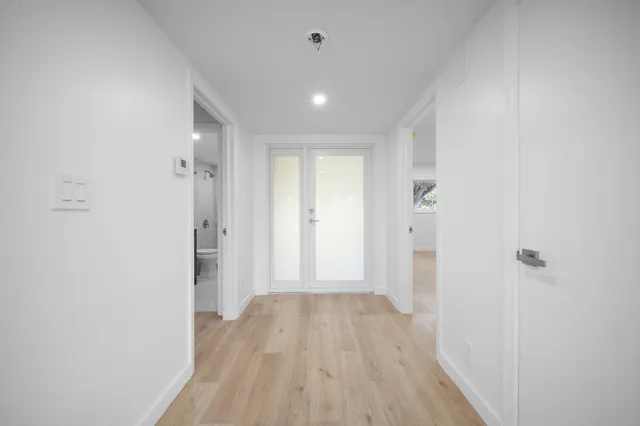 a view of a hallway with wooden floor