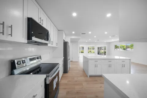 a large kitchen with stainless steel appliances lots of counter space sink and cabinets