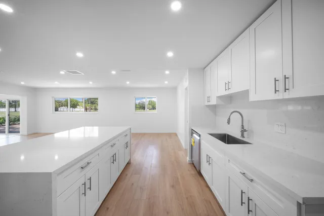 a large kitchen with a large counter top appliances and cabinets