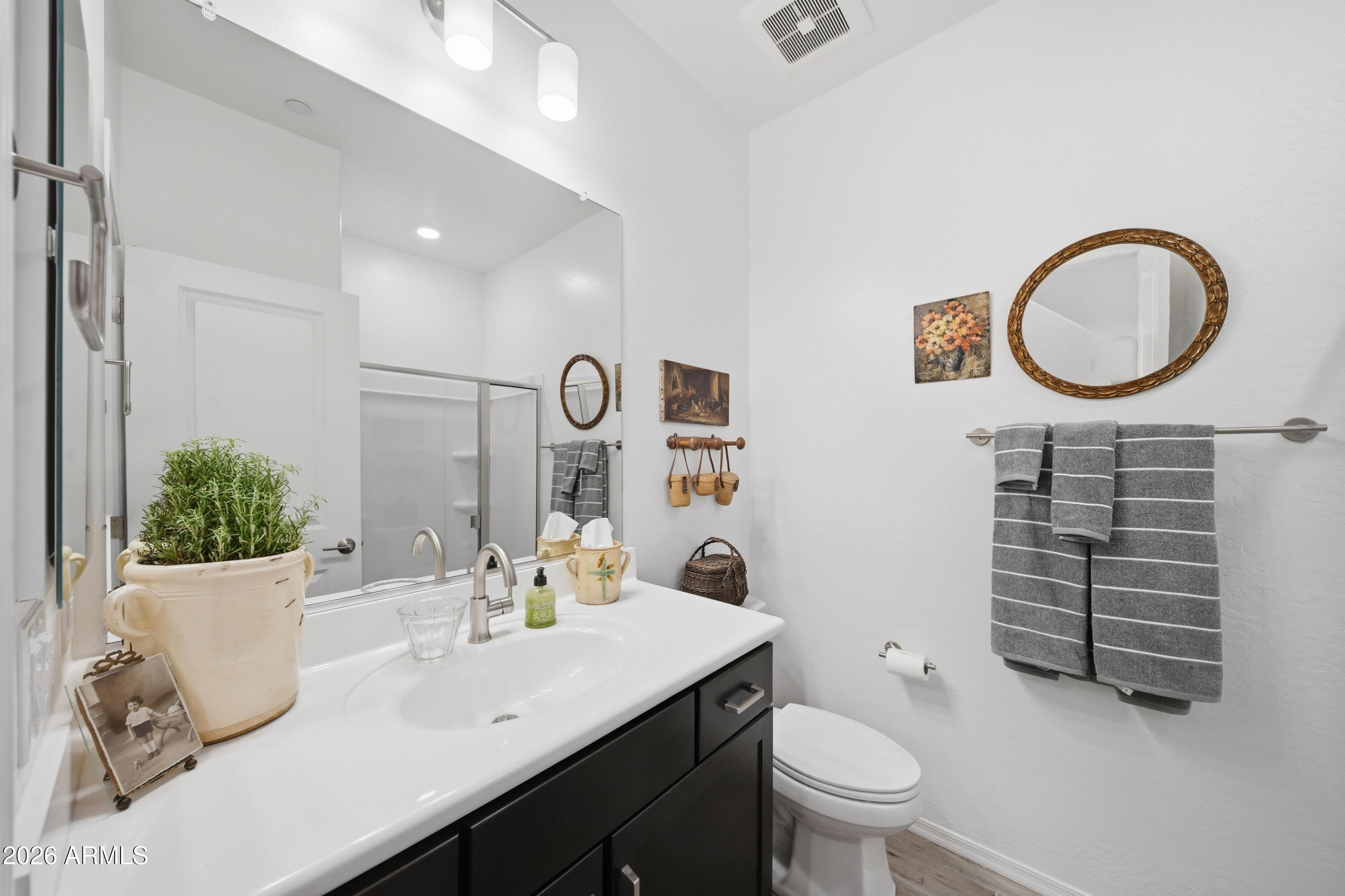 1917 East Hampton Lane, Unit 106 Gilbert, AZ 85295 - Photo 16 of 25 a bathroom with a granite countertop toilet a sink and a mirror
