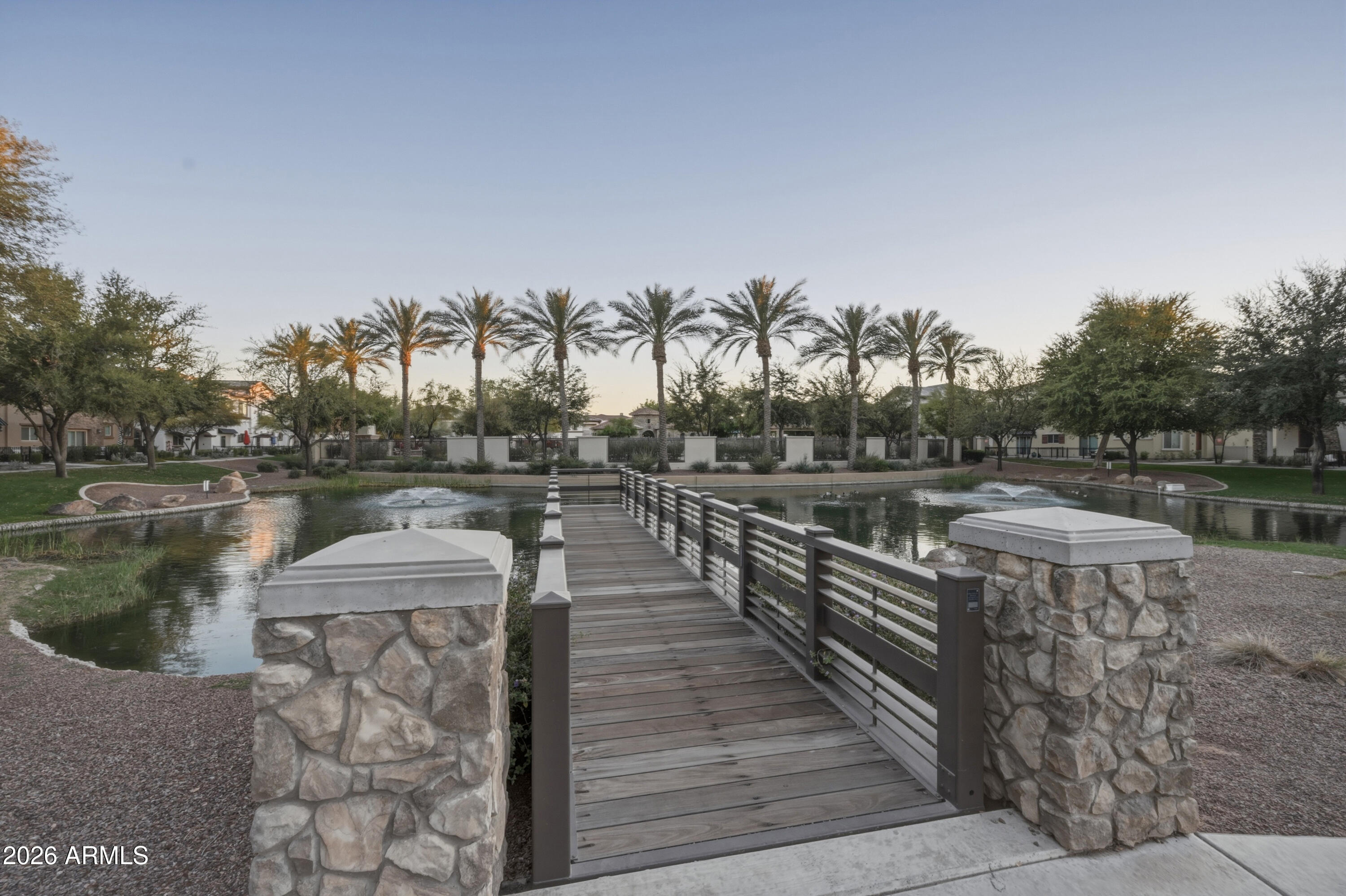1917 East Hampton Lane, Unit 106 Gilbert, AZ 85295 - Photo 3 of 25 a view of a lake with a yard and large trees