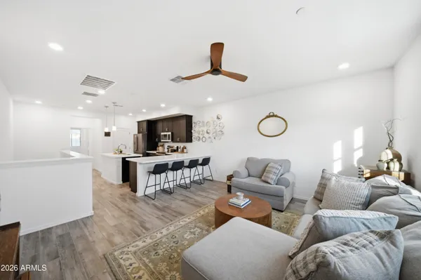 a living room with furniture a flat screen tv and kitchen view