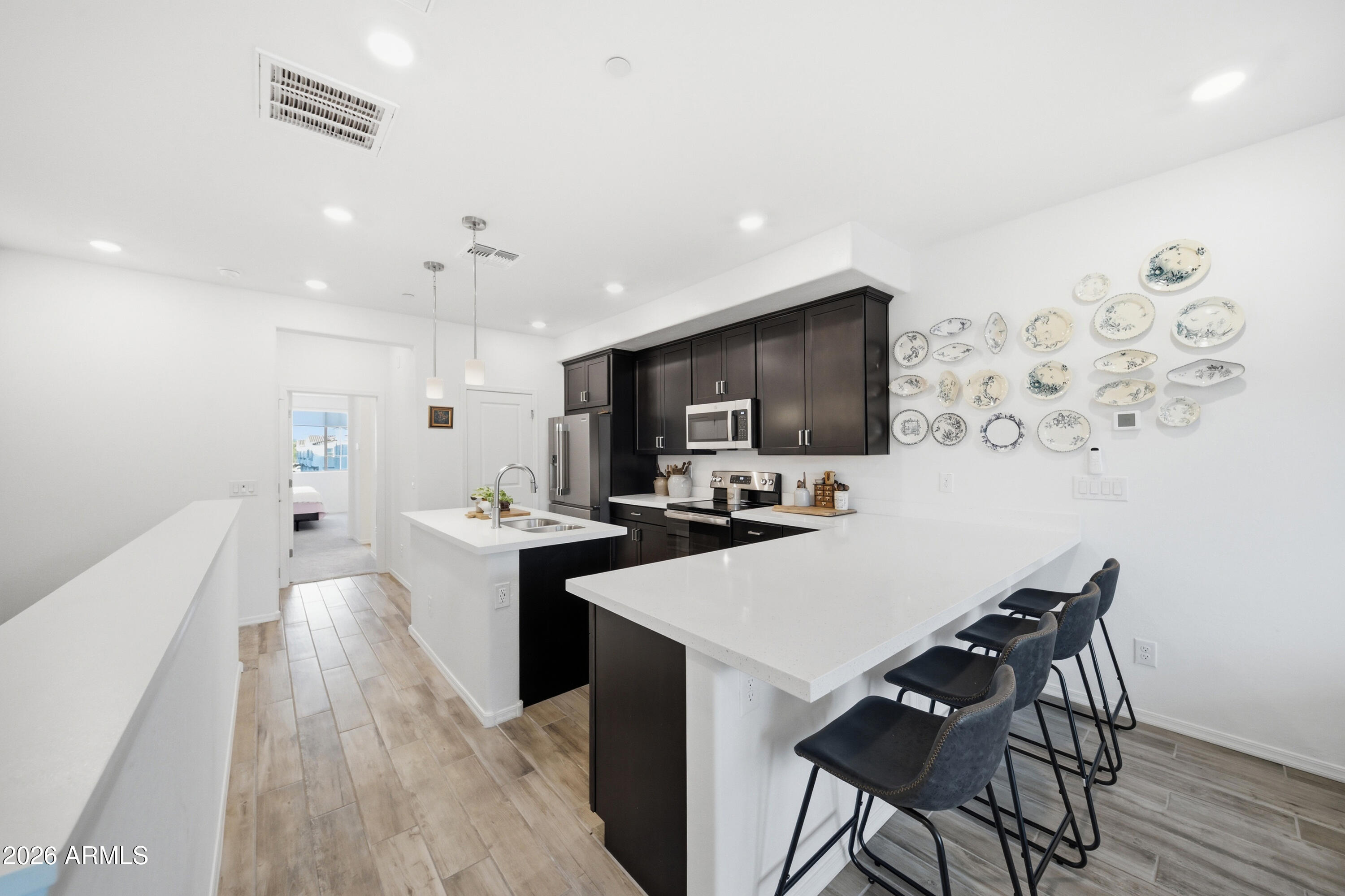 1917 East Hampton Lane, Unit 106 Gilbert, AZ 85295 - Photo 9 of 25 a kitchen with stainless steel appliances a sink a stove a refrigerator cabinets and a dining table