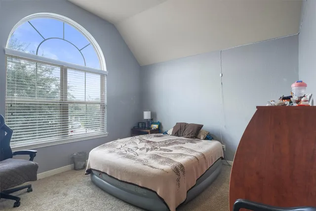 a bedroom with a bed and a large window