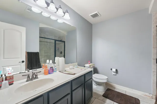 a bathroom with a double vanity sink mirror and toilet