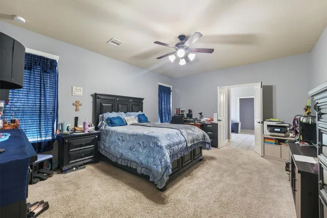 a spacious bedroom with a bed a table and chair