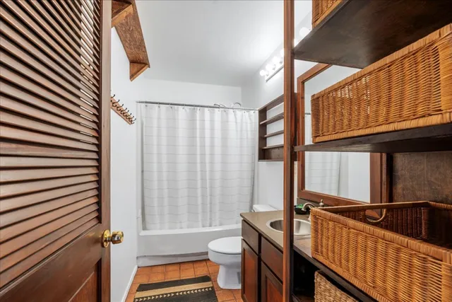 a bathroom with a sink a toilet a mirror and shower