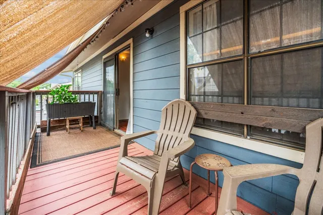 a view of a patio with table and chairs with wooden floor and fence