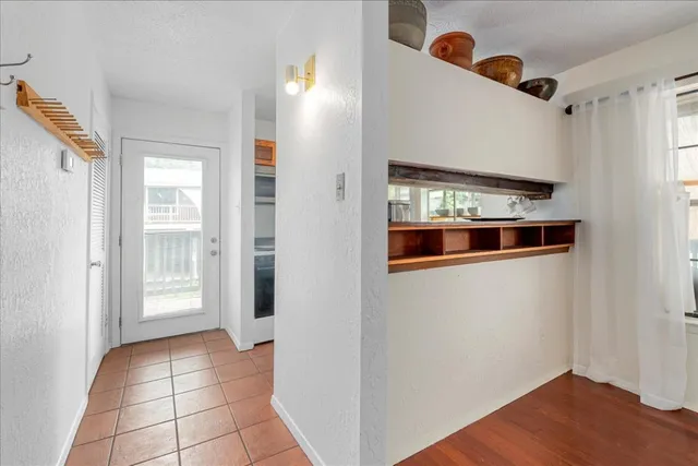 a view of a hallway with wooden floor and windows in a room