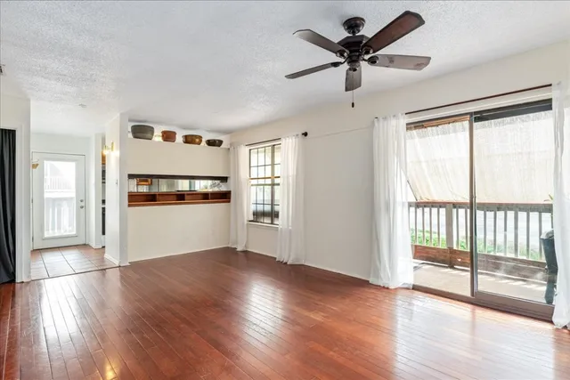 a view of a kitchen with a ceiling fan hardwood floor and a ceiling fan