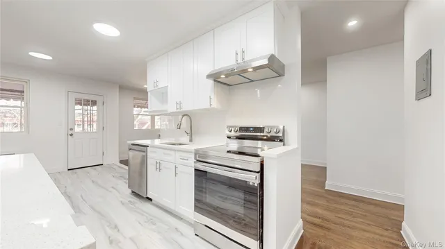 a kitchen with a stove cabinets and wooden floor