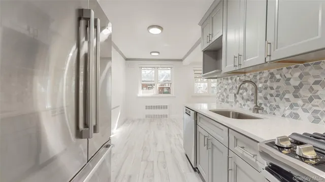 a kitchen with stainless steel appliances granite countertop a sink and a refrigerator