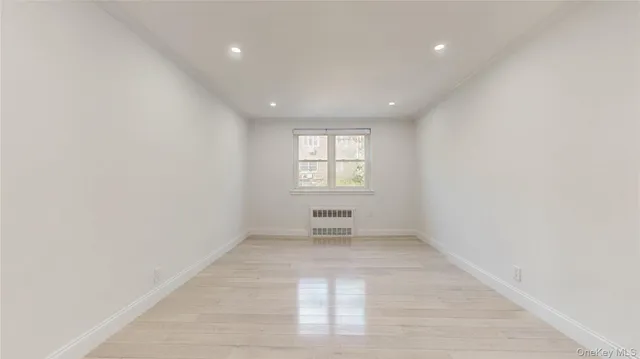 an empty room with white walls and windows