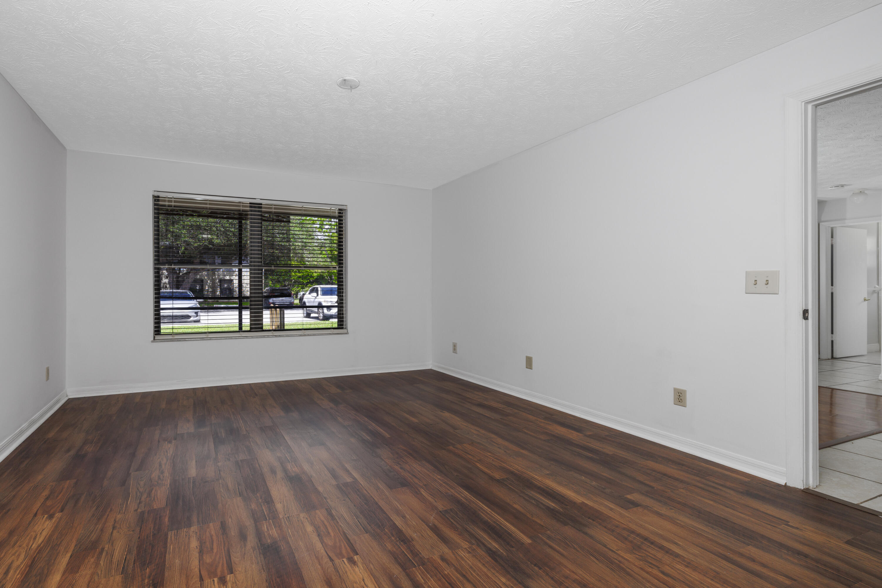 6541 Southeast Federal Highway, Unit 101 Stuart, FL 34997 - Photo 17 of 30 a view of an empty room with wooden floor and a window