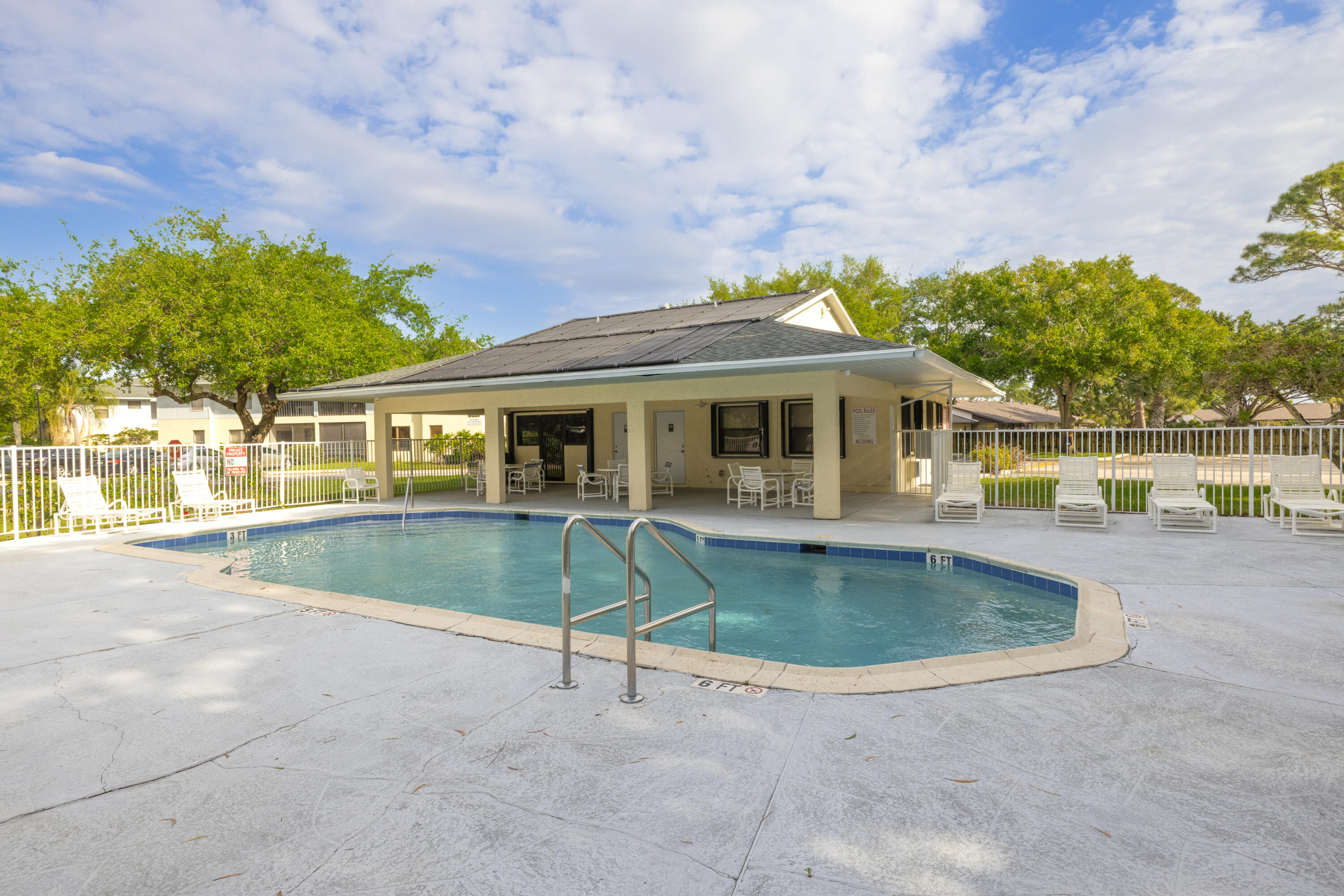 6541 Southeast Federal Highway, Unit 101 Stuart, FL 34997 - Photo 25 of 30 a view of pool with a table and chairs under an umbrella