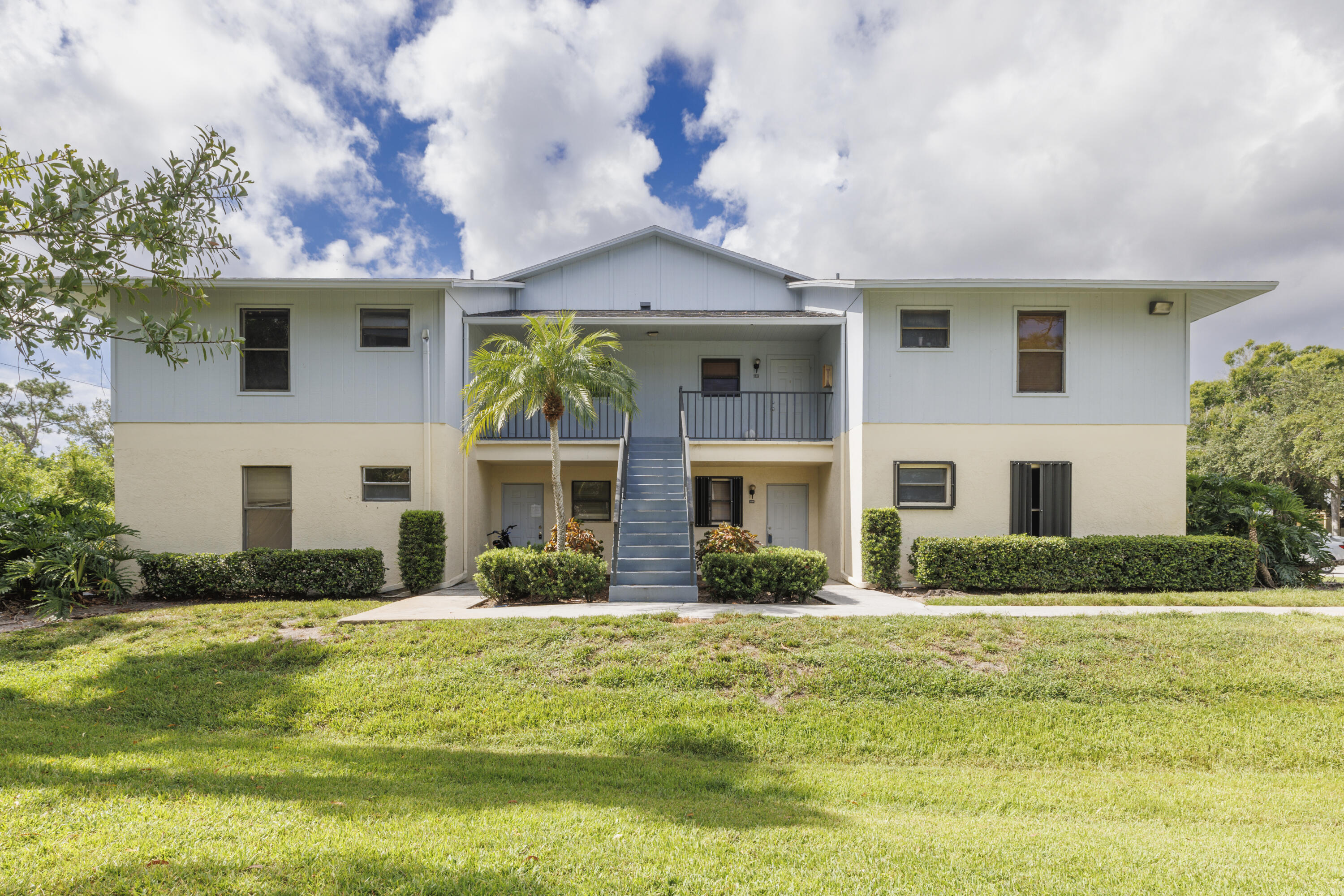 6541 Southeast Federal Highway, Unit 101 Stuart, FL 34997 - Photo 3 of 30 a front view of a house with a yard