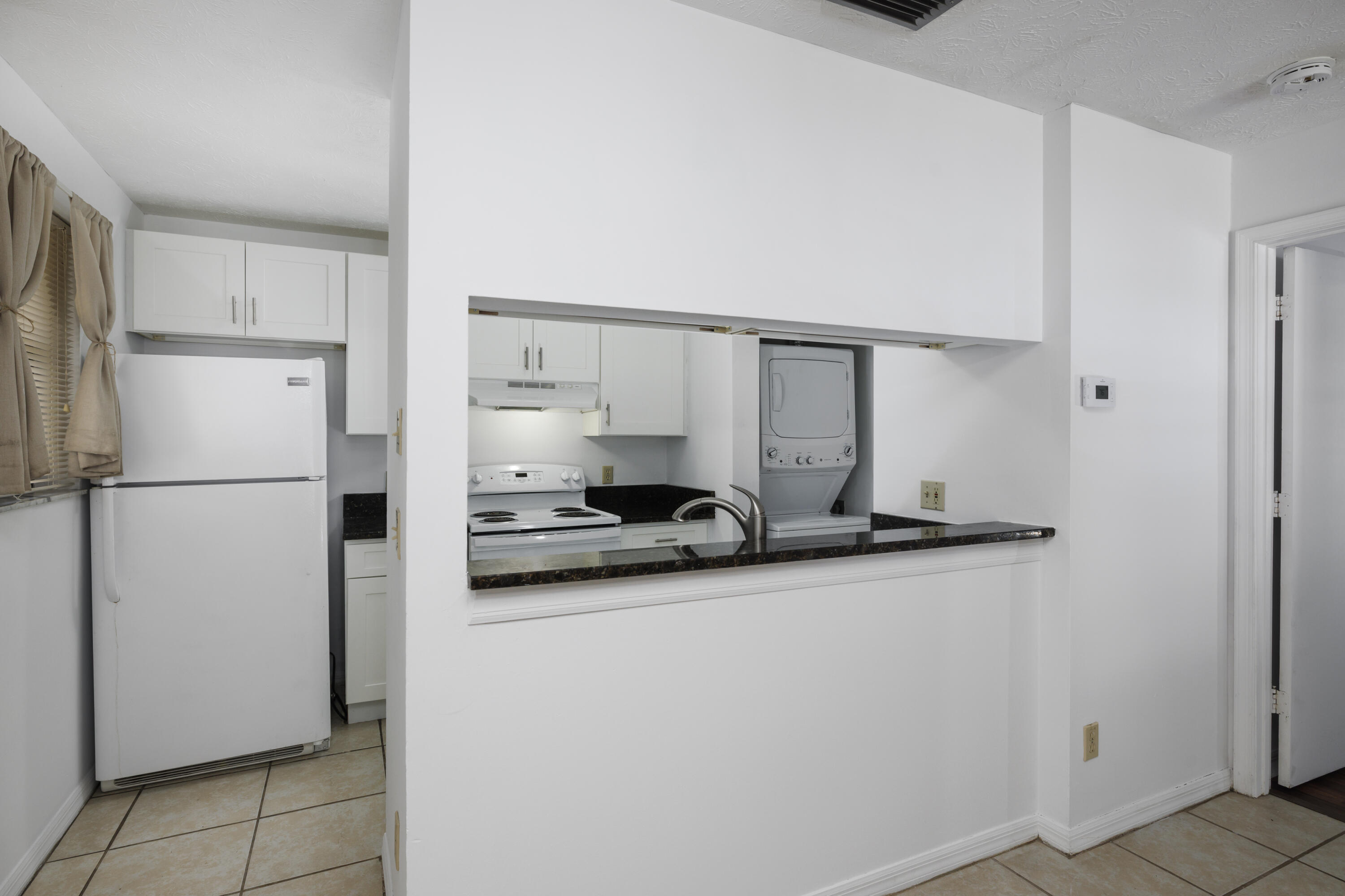 6541 Southeast Federal Highway, Unit 101 Stuart, FL 34997 - Photo 9 of 30 a kitchen with stainless steel appliances a sink and a refrigerator