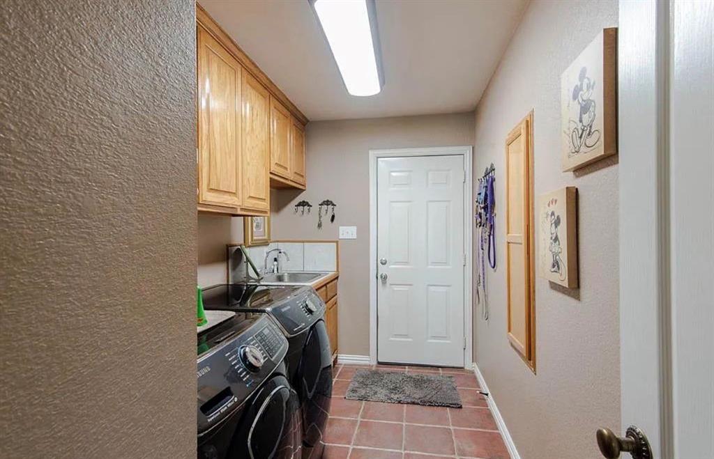 10899 Jackson Road Krum, TX 76249 - Photo 5 of 11 Laundry area with a textured wall, light tile patterned floors, cabinet space, and independent washer and dryer