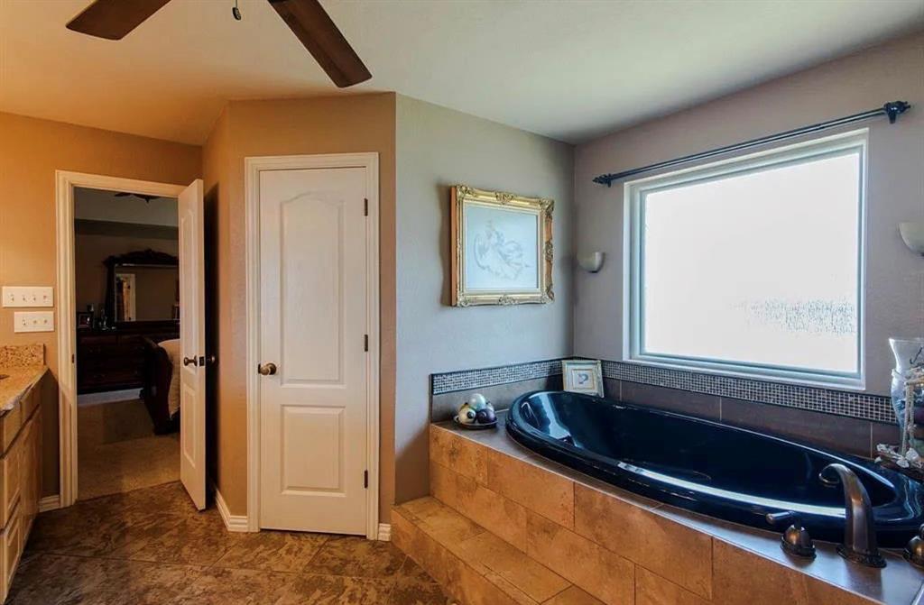 10899 Jackson Road Krum, TX 76249 - Photo 7 of 11 Ensuite bathroom with vanity, ceiling fan, and a garden tub