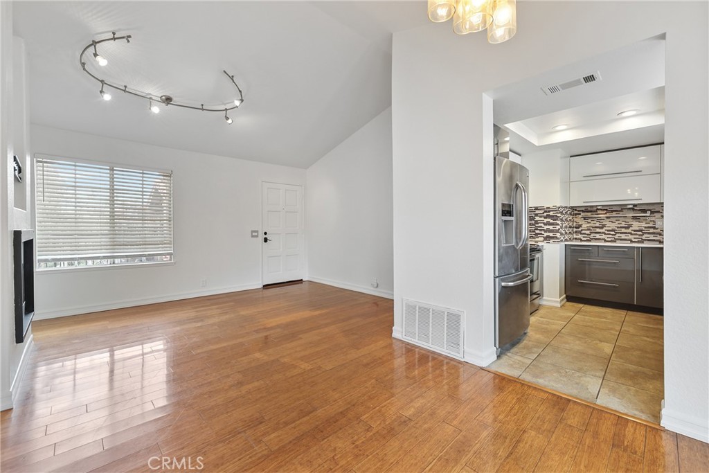 4 Dogwood Rancho Santa Margarita, CA 92688 - Photo 4 of 18 an empty room with wooden floor kitchen view and windows