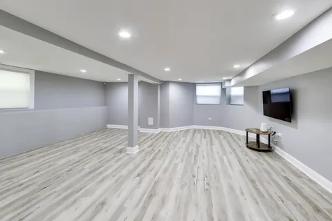 a view of a livingroom with wooden floor and furniture