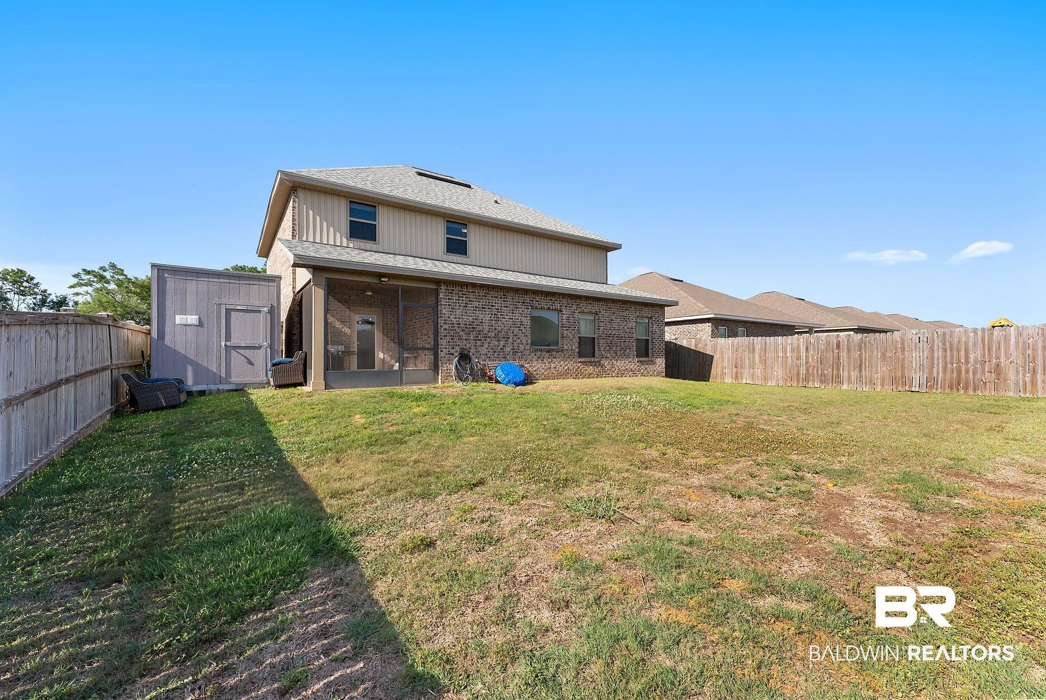 16607 Prado Loop Loxley, AL 36551 - Photo 42 of 46 Spacious backyard featuring a wood privacy fence, a screened patio, and a dedicated storage shed