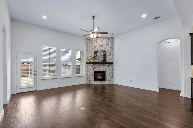 a large kitchen with stainless steel appliances kitchen island a large counter top and wooden floors