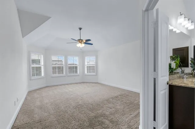 an empty room with wooden floor fireplace and windows