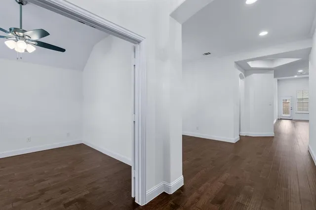 a view of an empty room with wooden floor