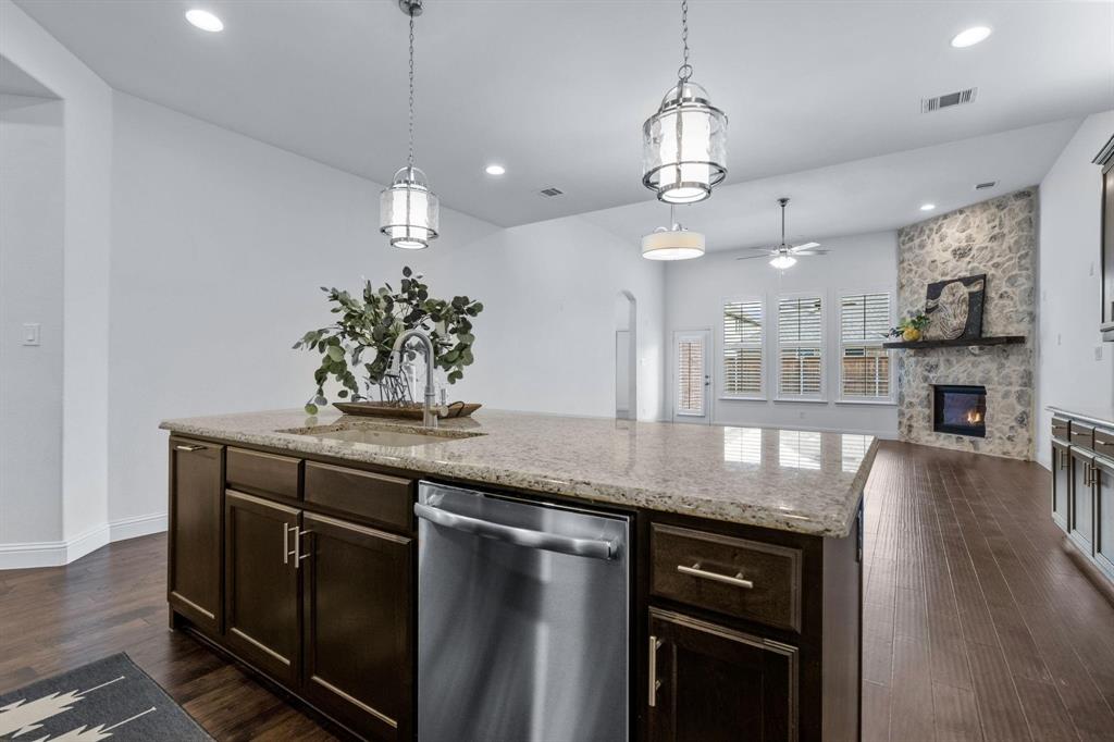 4220 Harper Avenue Celina, TX 75009 - Photo 8 of 20 a kitchen with stainless steel appliances granite countertop a sink a stove and a wooden floors