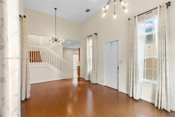 a view of a hallway with wooden floor and cabinet