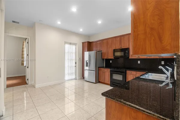 a view of kitchen with refrigerator and microwave