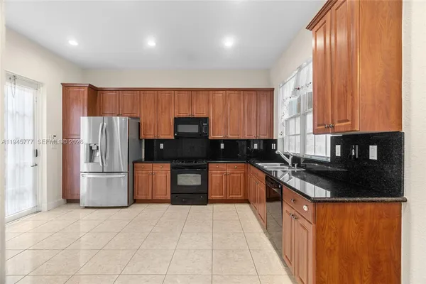 a kitchen with stainless steel appliances granite countertop a stove a sink dishwasher a refrigerator and a microwave oven